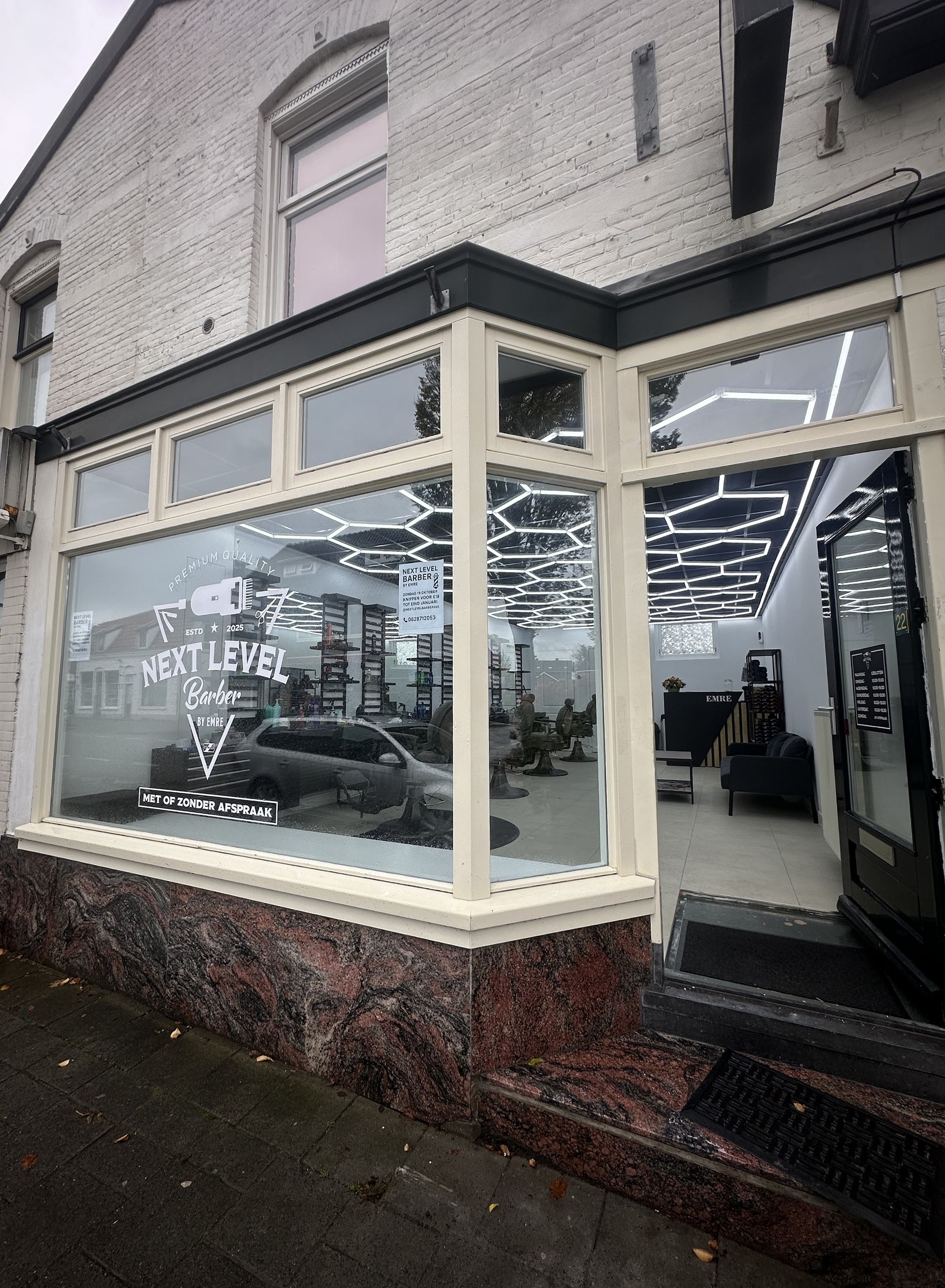 De gevel van NextLevelBarber aan de Laarderweg, met het logo en 'met of zonder afspraak' op het raam